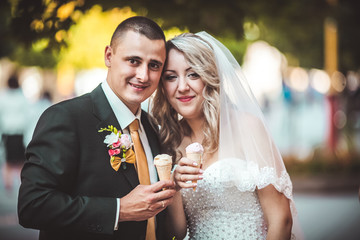 Beautiful young wedding couple enjoying ice cream