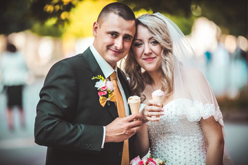 Beautiful young wedding couple enjoying ice cream