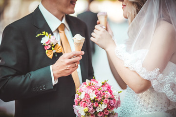 Beautiful young wedding couple enjoying ice cream
