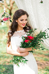 Obraz na płótnie Canvas Wonderful bride in amazing dress with red roses