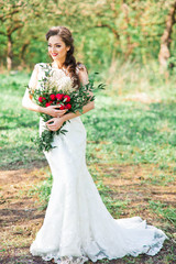 Fototapeta na wymiar Beautiful bride in amazing dress with red roses