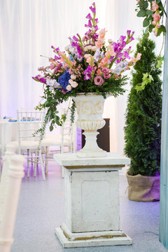 Wedding floral decorations. Flowers in vase, columns and table