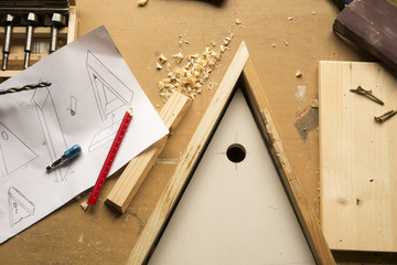 build birdhouse, wood, screws and tools lying on the bench