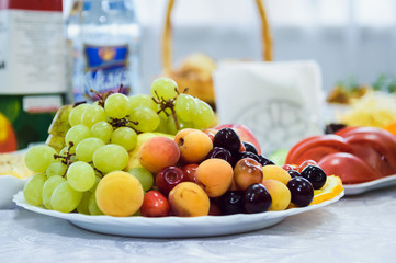 tasty fruit on a plate with cherries, grapes, apricots