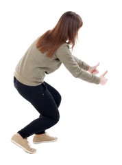 Back view of  woman thumbs up. Rear view people collection. backside view of person. Isolated over white background. slender blonde in a jeans shows the symbol of success or hitchhiking. To the bottom