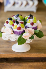 Delicious candy bar Dessert table for outdoor party. Ombre cake, cupcakes, sweetness, berries and flowers