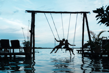 Silhouette of couple on the swings