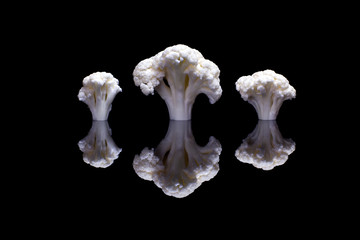  Three cauliflowers on a shiny black background