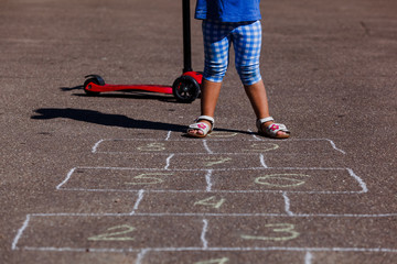 little girl playing hopscotch on playground