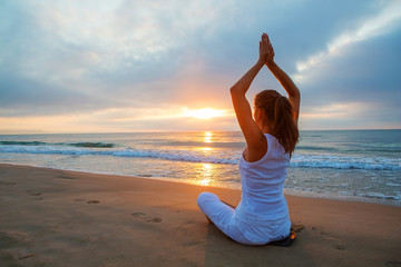 Fototapeta na wymiar Caucasian woman practicing yoga at seashore