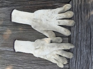Dirty old white glove on wood background