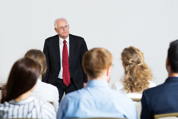 Portrait of Senior Male Business Expert Listening Questions at S