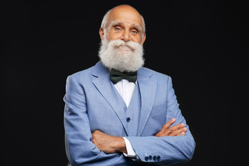 Elderly man in a stylish grey suit on black background