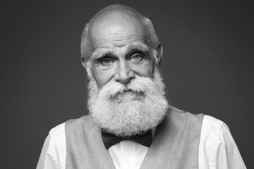 Elderly bearded man in stylish suit on grey background