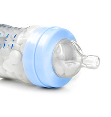 Baby bottle full of pills isolated on white