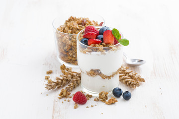 healthy dessert with natural yogurt, muesli and berries on white