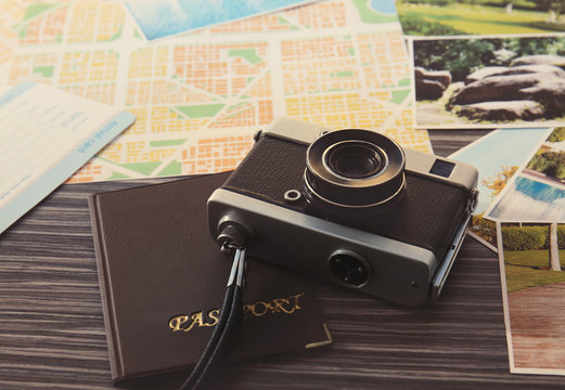 Vintage camera, map and passport on wooden table