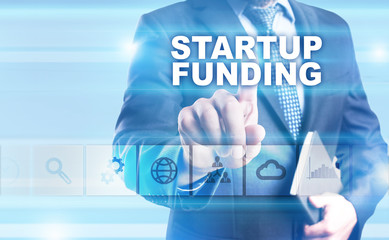 Businessman is pressing button on touch screen interface and selecting "Startup funding".