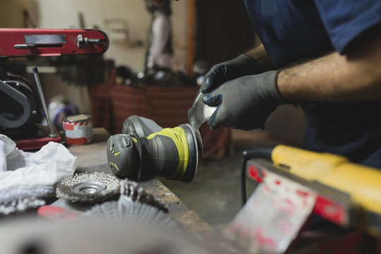 Forger treating metal in workshop