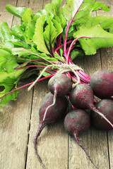 Young,fresh beets with tops on old wooden background.Style rustic.Selective focus