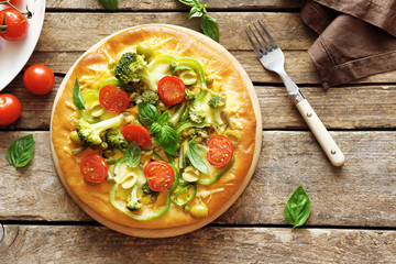 Plate with tasty vegetarian pizza on wooden table