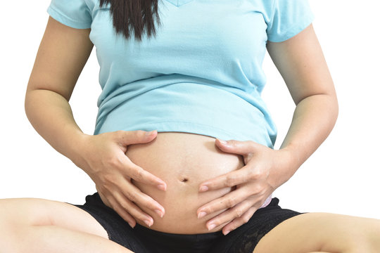 pregnant woman image touching her belly with hands white background.