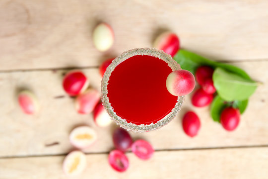 Carandas-plum  juice  in a glass on wooden background  