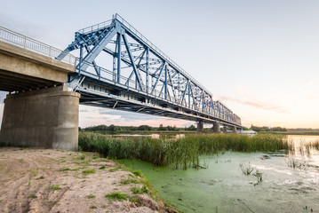 Fototapeta premium railway bridge with metal rails near river