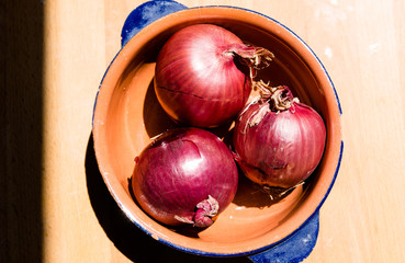 Tre cipolle rosse in una scodella