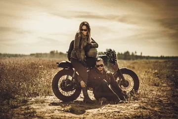 Papier Peint photo autocollant Moto Stylish cafe racer couple on the vintage custom motorcycles in a field.