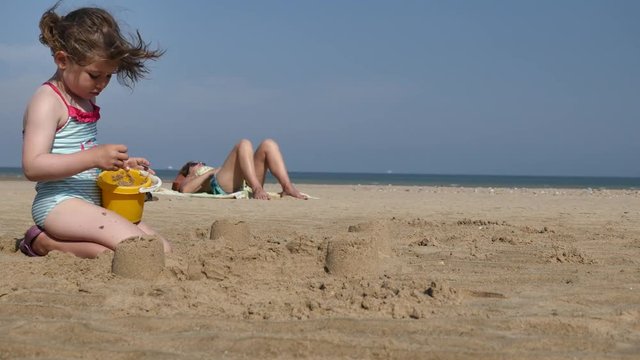 jolie jeune fille et sa maman sur la plage(4k)