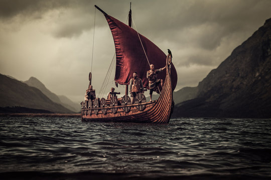Vikings are floating on the sea on Drakkar with mountains on the