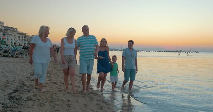 Big happy funny family walks on the beach and dancing at the same time against evening sea background Piraeus, Greece