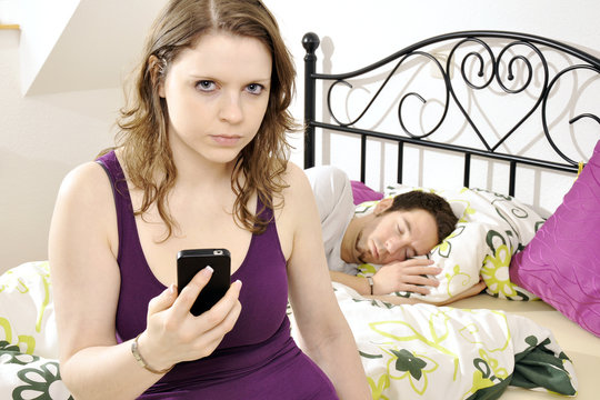Frau schnüffelt heimlich, eifersüchtig und neugierig in Handy oder Smartphone von Mann
