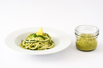 Zucchini noodles with pesto sauce isolated on white background

