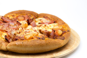 Hawaiian pizza on a wooden tray.