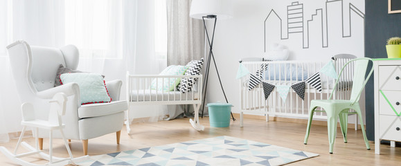 Light and spacious baby room with window, armchair, cradle, cot, chair, commode and blackboard, panorama