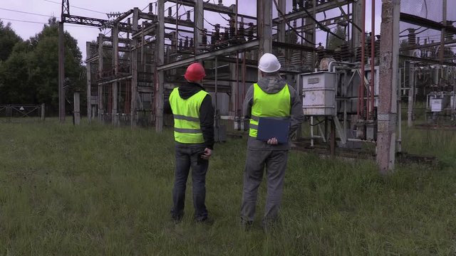 Electricians talking in electrical substation

