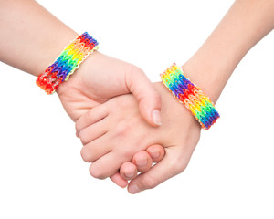 woman's hands with a bracelet patterned as the rainbow flag. isolated on white