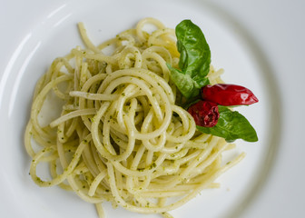 Italian pasta spaghetti with homemade pesto sauce and basil leaf