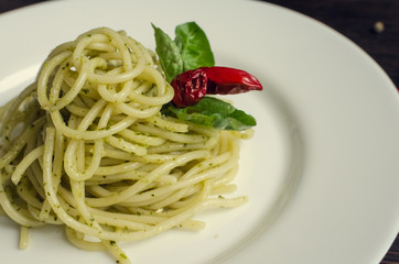 Italian pasta spaghetti with homemade pesto sauce and basil leaf