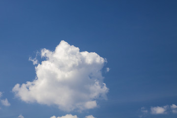 Blue sky with puffy white clouds in bright clear sunny day