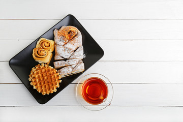 Tea and pastry on white wooden table