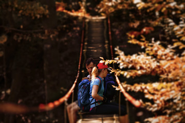 Obraz na płótnie Canvas Young couple having rest on bridge at forest