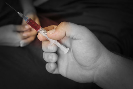 Stabbing drugs. the syringe and the hand enters injections, drugs, doping.