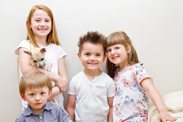 foto di gruppo di quattro bambini con un cagnolino - obrazy, fototapety, plakaty
