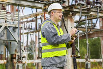 Electrician writing in electrical substation