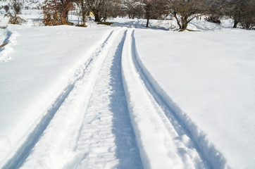 Fototapeta na wymiar car wheel trail in the snow, ice