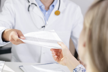 doctor give a document to patient - obrazy, fototapety, plakaty