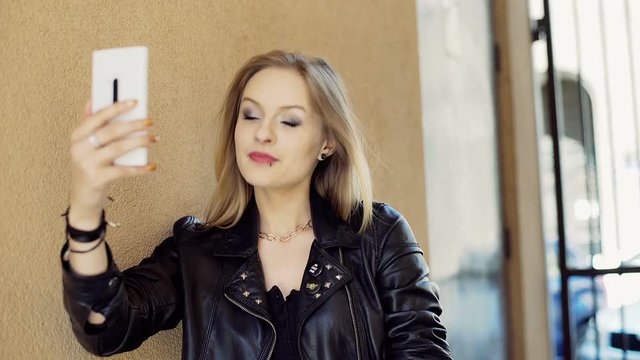 Punk girl doing selfies on smartphone and enjoying this, steadycam shot
